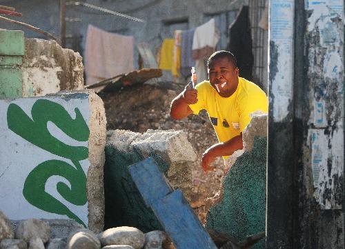 A man brushes teeth at his ruined home in Port-au-Prince, capital of Haiti, on January 22, 2010, 10 days after a catastrophic earthquake hit the nation on January 12.