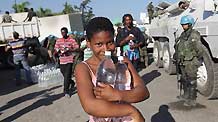 A girl receives bottled water at an aid distribution site in Port-au-Prince, capital of Haiti, on January 22, 2010, 10 days after a catastrophic earthquake hit the nation on January 12.