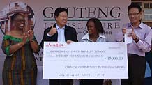 Chinese Consul General to Johannesburg Fang Li (2nd, L) donates funds on behalf of overseas Chinese to a local elementary school in Diepkloop, Soweto, Johannesburg, South Africa, January 22, 2010.