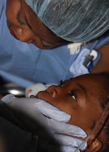 A Haitian girl receives treatment at a medical assistance station in Port-au-Prince, Haiti, January 22, 2010. Nine medical teams, including US, France, Russia, China, provide medical treatments for Haiti in this station.