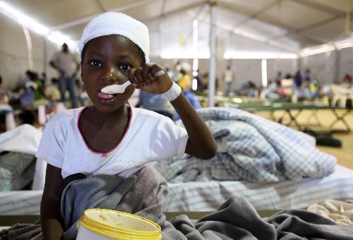 A Haitian boy have his lunch after receiving treatment at a medical assistance station in Port-au-Prince, Haiti, January 22, 2010. Nine medical teams, including US, France, Russia, China, provide medical treatments for Haiti in this station.
