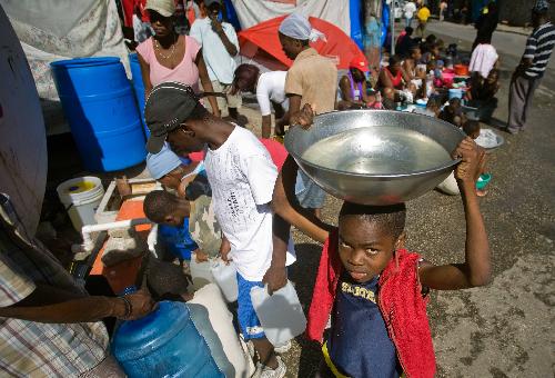 Local citizens store water at a makeshift shelter in Port-au-Prince, Haiti, January 22, 2010.