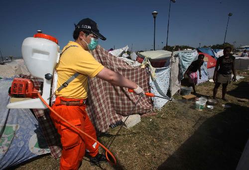 A member of Chinese rescuers disinfects the temporary shelter of quake victims in Port-au-Prince, Haiti, January 23, 2010. The Haitian government said that the number of people killed in the devastating earthquake has surpassed 110,000 on Friday.