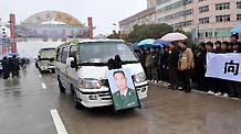 Local people hold banners to bid farewell to Zhong Jianqin, a Chinese peacekeeping police officer who were killed in the 7.3-magnitude earthquake in Haiti, as a vehicle carrying his bone ash passes by in Nanfeng county of east China's Jiangxi Province, January 23, 2010.