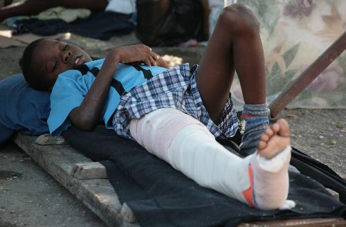An injured Haitian child receiving treatment lies in a temporary hospital in Port-au-Prince, Haiti, January 23, 2010.