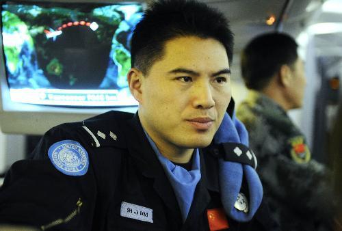 Chinese peacekeeping police officer Shi Jindong talks with his workmate on a chartered flight for Haiti, on January 24, 2010. 