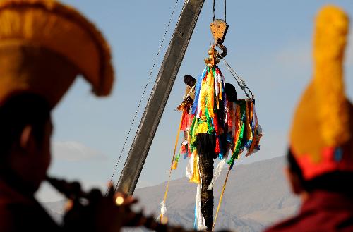Workers replace prayer streamers around the Jokhang Temple in Lhasa, capital of southwest China&apos;s Tibet Autonomous Region, January 26, 2010. 
