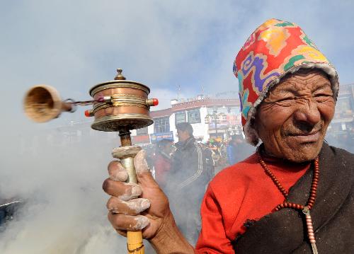 An elderly Buddhist believer holds a prayer wheel during the replacement ceremony of prayer streamers around the Jokhang Temple in Lhasa, capital of southwest China&apos;s Tibet Autonomous Region, January 26, 2010.