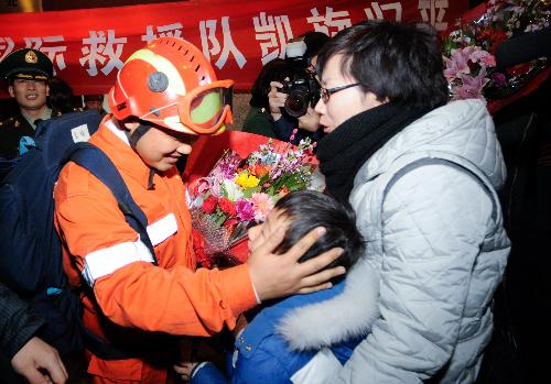 A member of China International Search and Rescue Team (CISAR) embraces his family members at Capital International Airport in Beijing, capital of China, on January 27, 2010. China International Search and Rescue Team (CISAR) accomplished the rescue and medical care task in quake-devastated Haiti and returned to Beijing on Wednesday. 