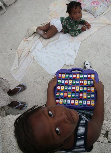 A Haitian child holds a donated toy in Haitian capital Port-au-Prince on January 25, 2010. Life for locals began to recover from the chaos caused by a catastrophic earthquake that rocked the city on January 12.