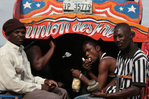 People ride on a bus in Haitian capital Port-au-Prince on January 25, 2010. Life for locals began to recover from the chaos caused by a catastrophic earthquake that rocked the city on January 12.