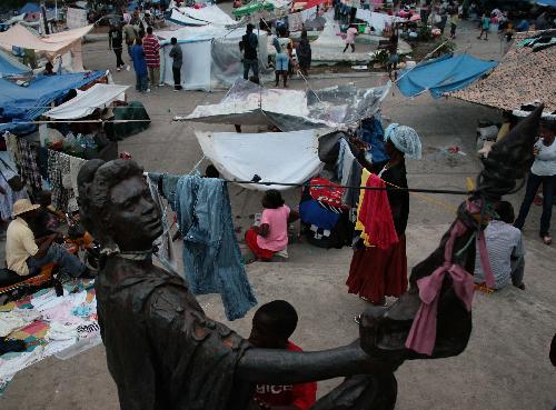 People live in a temporary settlement in Haitian capital Port-au-Prince on January 25, 2010. Life for locals began to recover from the chaos caused by a catastrophic earthquake that rocked the city on January 12. 