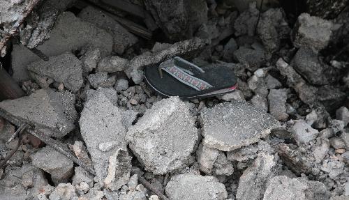 A slipper is pictured on the rubble of a destroyed building in Haitian capital Port-au-Prince on January 25, 2010. Life for locals began to recover from the chaos caused by a catastrophic earthquake that rocked the city on January 12.