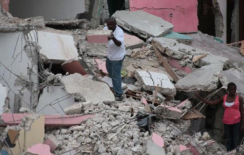 People search for survivors and useful items on the rubble of a destroyed building in Haitian capital Port-au-Prince on January 25, 2010. 