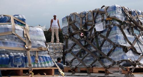 A man stands on a batch of relief goods in Haitian capital Port-au-Prince on Januaary 25, 2010.