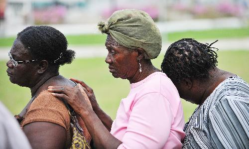 Three women wait to receive relief materials in Haitian capital Port-au-Prince, on January 26, 2010, the 15th day after the catastrophic earthquake.