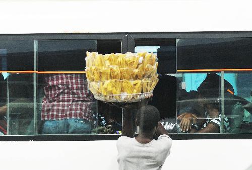 A vender sells food to the passengers on a bus in the street in Port-au-Prince, capital of Haiti, January 26, 2010.
