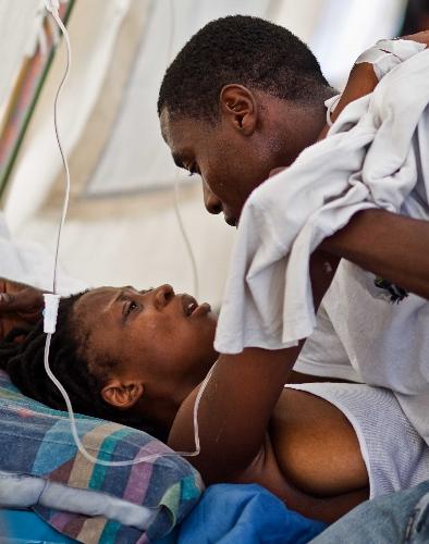 A woman injured in the earthquake is comforted by her husband after the amputation in a hospital in Port-au-Prince, capital of Haiti, January 26, 2010.