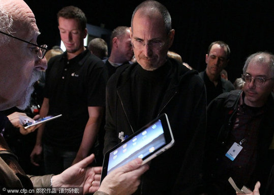 CEO Steve Jobs (C) talks with Technology Columnist Walt Mossberg (L) of the Wall Street Journal during an Apple Special Event at Yerba Buena Center for the Arts January 27, 2010 in San Francisco, California. CEO Steve Jobs and Apple Inc. introduced its latest creation, the iPad, a mobile tablet browsing device that is a cross between the iPhone and a MacBook laptop. [CFP]