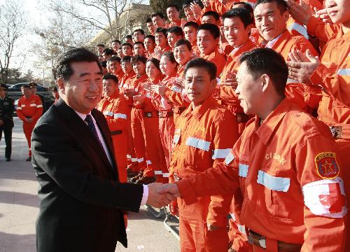 Chinese Vice Premier Hui Liangyu (L Front) shakes hands with members of the China International Search and Rescue Team (CISAR) in Beijing, capital of China, on January 27, 2010. 
