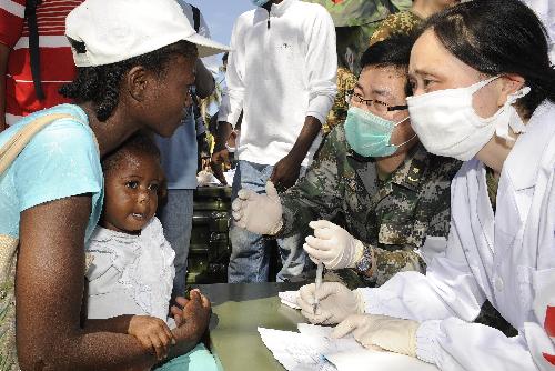 A member of a Chinese medical team asks about a child's symptoms at a makeshift hospital that the team has set up in Port-au-Prince January 27, 2010. 