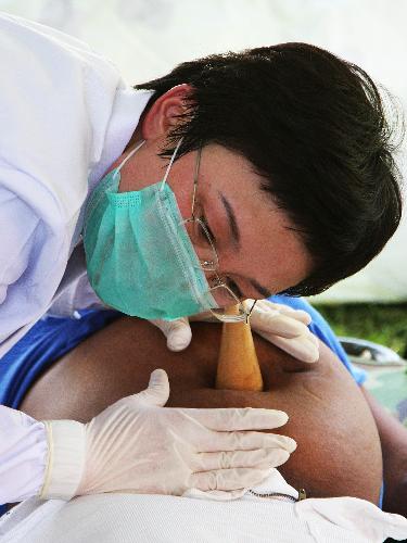 A member of a Chinese medical team performs diagnosis for a pregnant woman at a makeshift hospital that the team has set up in Port-au-Prince January 27, 2010. 