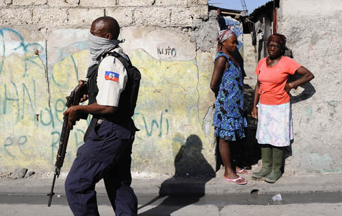 A Haitian policeman searches for runaway prisoners in Port-au-Prince, capital of Haiti, January 28, 2010. 