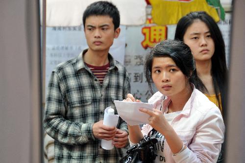 A student writes down information at a job fair for college graduates in Haikou, capital of south China's Hainan Province, January 29, 2010. A total of 3,900 job vacancies were provided at the job fair, which attracted more than 4,000 graduates.