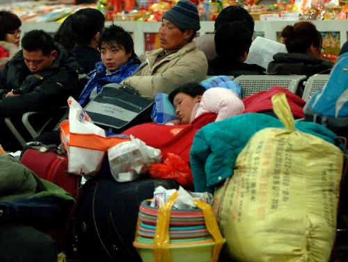 Passengers wait for trains at the West Railway Station in Beijing, capital of China, January 30, 2010. China's railways are expected to transport 210 million passengers during the 40-day travel peak starting from January 30, as people return home for family reunion in the traditional Spring Festival beginning from February 14 this year and then go back to workplaces.