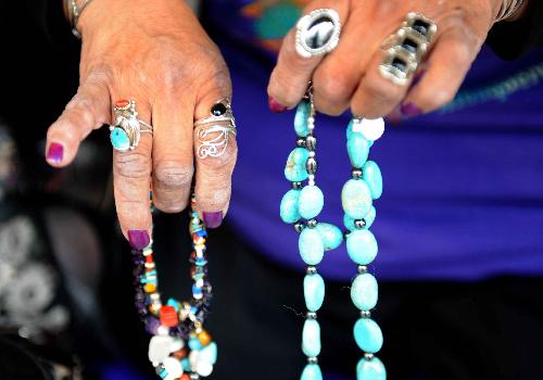 An Indian woman shows the handmade jewelry in the old town of