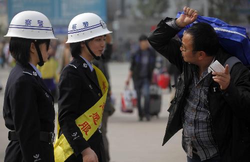 Photo taken on January 30, 2010 shows students from local police school helping railway passengers at the Railway Station in Guangzhou, south China's Guangdong Province. China on Saturday began its annual mass passenger transportation for the traditional Lunar New Year, with an expected 2.54 billion journeys in the coming 40 days.