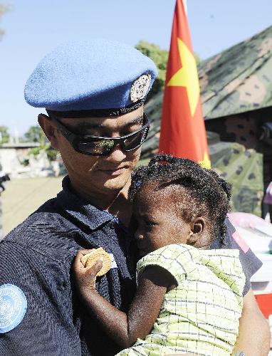 A member of the Chinese anti-riot police team in Haiti holds an orphan in his arms at the orphanage 'solidarity and fraternity' in Port-au-Princes, capital of Haiti, January 30, 2010. 