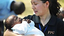 A member of the Chinese anti-riot police team in Haiti holds a four-month-old orphan in her arms at the orphanage 'solidarity and fraternity' in Port-au-Princes, capital of Haiti, January 30, 2010.