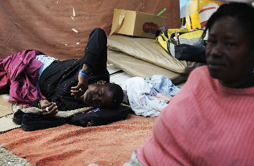 People rest at a temporary settlement for quake victims outside the presidential palace in Port-au-Princes, capital of Haiti, January 31, 2010.