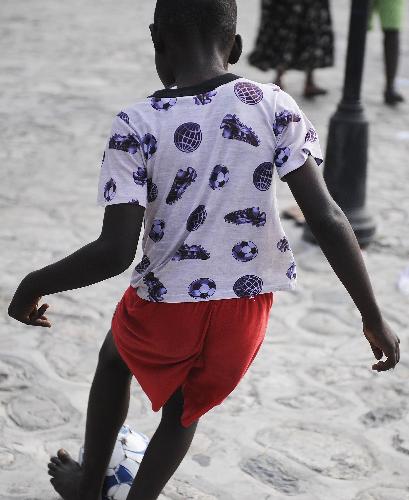 A boy plays football at a temporary settlement for quake victims outside the presidential palace in Port-au-Princes, capital of Haiti, January 31, 2010. 