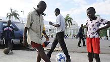 Boys play football at a temporary settlement for quake victims outside the presidential palace in Port-au-Princes, capital of Haiti, January 31, 2010.
