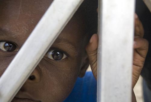 An orphan overlooks the outside in Port-au-Princes, capital of Haiti, January 30, 2010. Before the deadly earthquake, there were nearly 100,000 orphans in Haiti. 