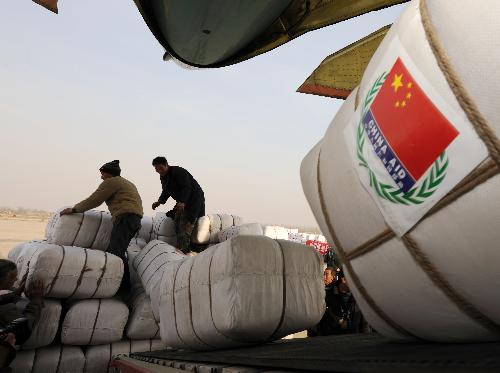 Chinese workers load emergency aid materials onto a transport plane at Zhengding International Airport in Shijiazhuang, capital of north China's Hebei Province, January 31, 2010.