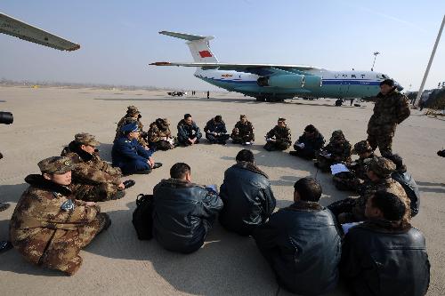 Crew members of three transport planes belonging to China Air Force discuss their upcoming transport mission at Zhengding International Airport in Shijiazhuang, capital of north China's Hebei Province, January 31, 2010.