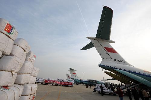 Chinese workers load emergency aid materials onto transport planes at Zhengding International Airport in Shijiazhuang, capital of north China's Hebei Province, January 31, 2010.