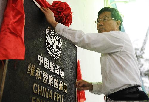 Wang Shuping, representative of China's trade development office in Haiti, presents red silk to the tablet of the Chinese peacekeeping anti-riot police team at the team's encampment in Port-au-Prince, capital of Haiti, February 1, 2010. 