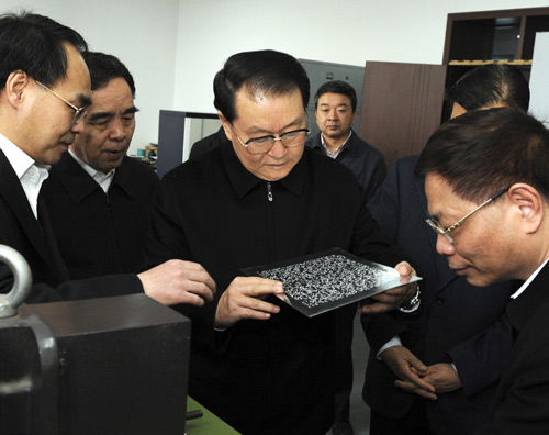 Li Changchun (front C), member of the Standing Committee of the Political Bureau of the Central Committee of the Communist Party of China(CPC), looks at an aluminium alloy printing plate during his visit to the China Braille Publishing House in Beijing, capital of China, February 2, 2010.