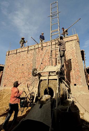 Workers build a new house in Guantun Village in Yao'an County, southwest China's Yunnan Province, February 2, 2010. 