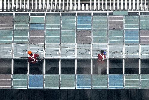 Technicians equip solar energy panels on the China Pavilion for 2010 World Expo in east China's Shanghai Municipality, February 3, 2010.