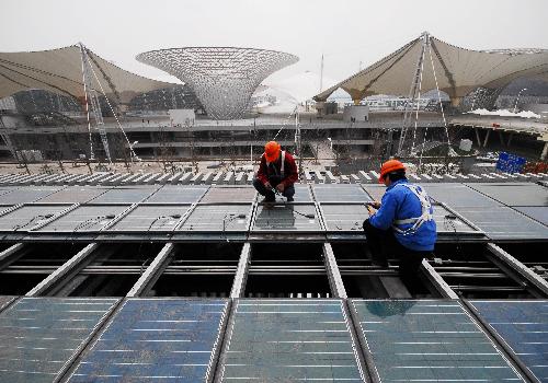 Technicians equip solar energy panels on the China Pavilion for 2010 World Expo in east China's Shanghai Municipality, February 3, 2010.