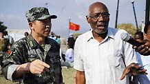 The delegate of Haiti's Health Department Roc Magloire (R) talks with the leader of Chinese medical team Liu Wendou during his visit at the clinic set up by the Chinese medical team in Port-au-Prince, capital of Haiti, on February 3, 2010.