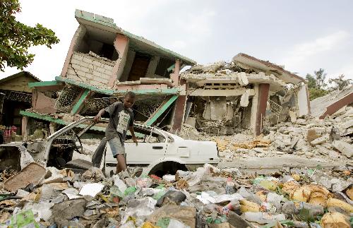 A boy searches for living materials among ruined houses in Port-au-Prince, capital of Haiti, February 6, 2010.