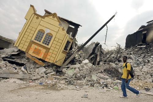A man searches for living materials among ruined houses in Port-au-Prince, capital of Haiti, February 6, 2010. 