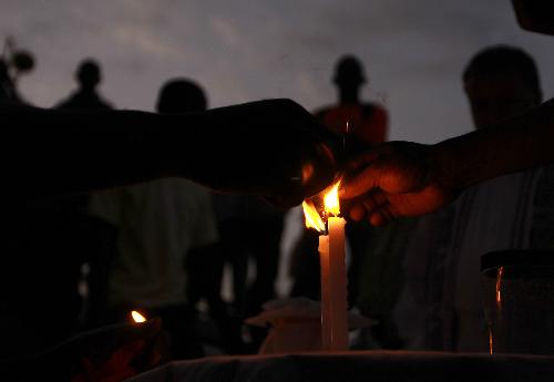 People light candles at the funeral of two American volunteers in Port-au-Prince, capital of Haiti, February 6, 2010.