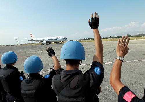 Members of the Chinese anti-riot team in Haiti wave goodbye to the Chinese medical team at the international airport in Port-au-Prince, capital of Haiti, February 8, 2010. 